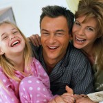 Happy Family Laughing in Bed